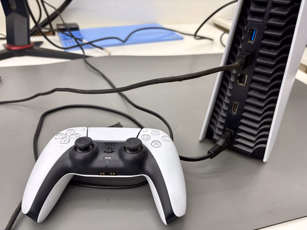 Controller die met een USB-kabel op de achterste poort van de console is aangesloten