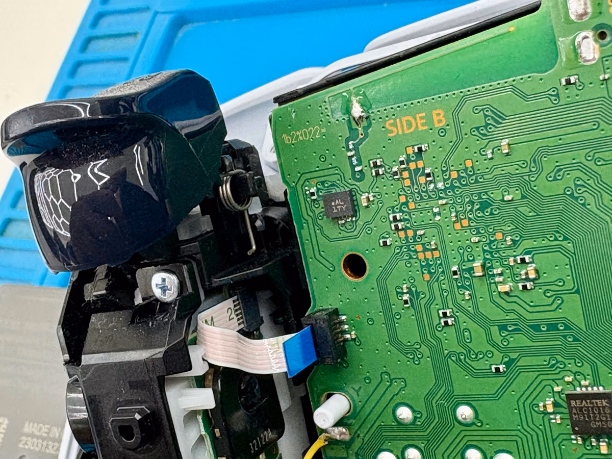 Gedemonteerde schouderknop of trigger met het veermechanisme zichtbaar