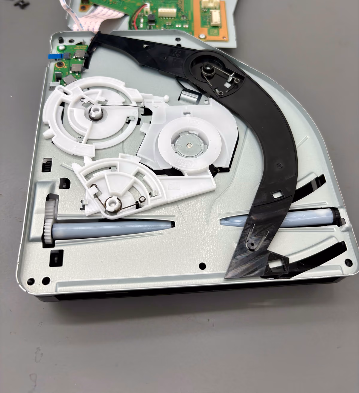 Geopende disc drive met de rollers en geleiders duidelijk zichtbaar