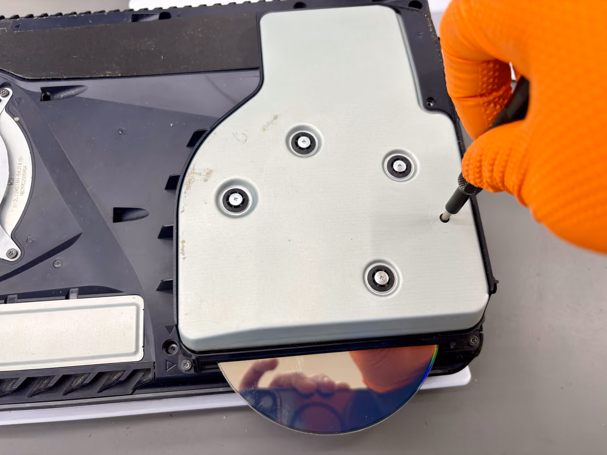 Vastgelopen disc die voorzichtig uit de drive wordt gehaald op de werkbank