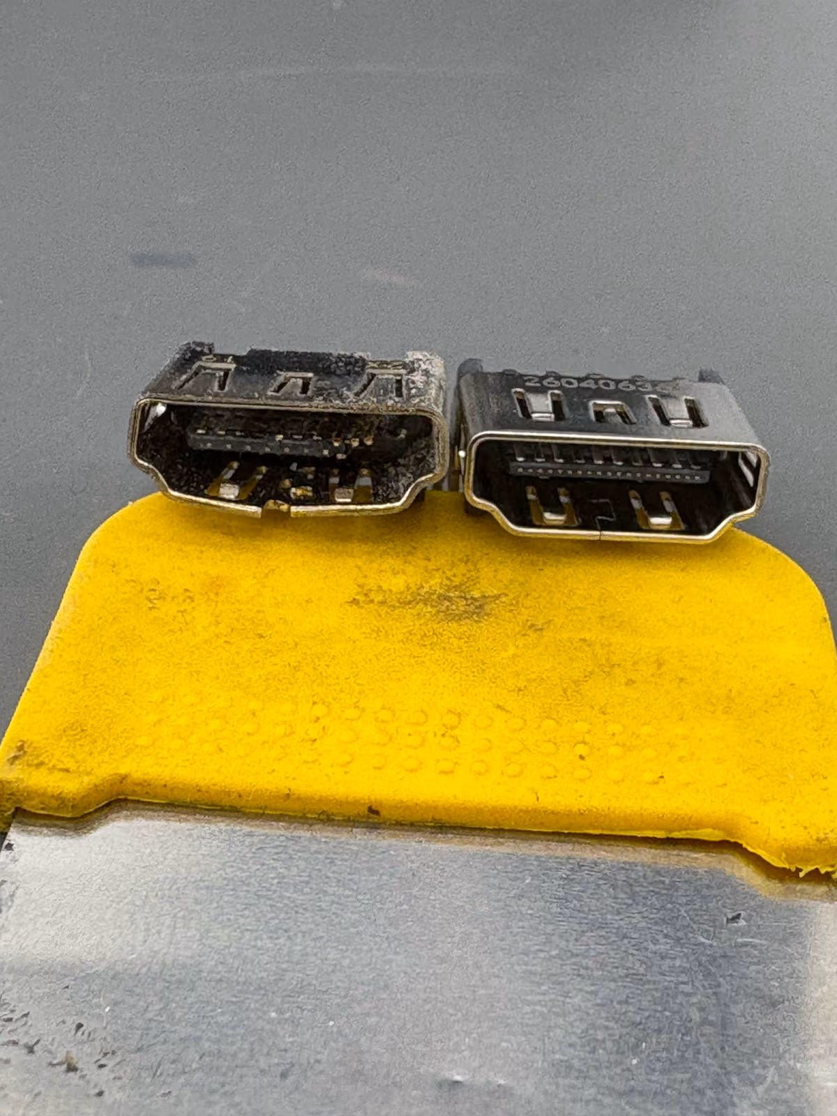 Losgesoldeerde HDMI-poort naast de nieuwe poort op de werkbank