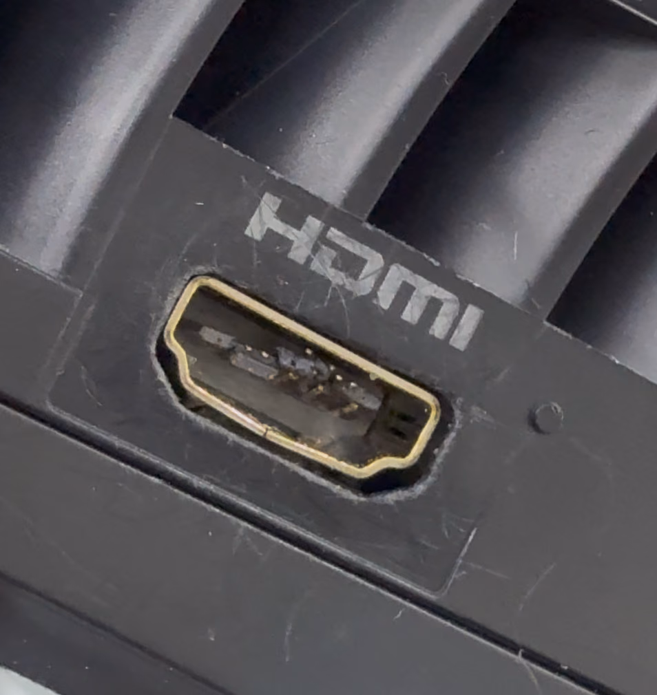 Macro-opname recht in een beschadigde HDMI-poort, met duidelijk zichtbaar verbogen pin