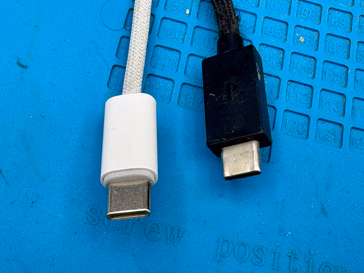 Twee USB-C kabels naast elkaar, waarvan één zichtbaar beschadigd bij de stekker