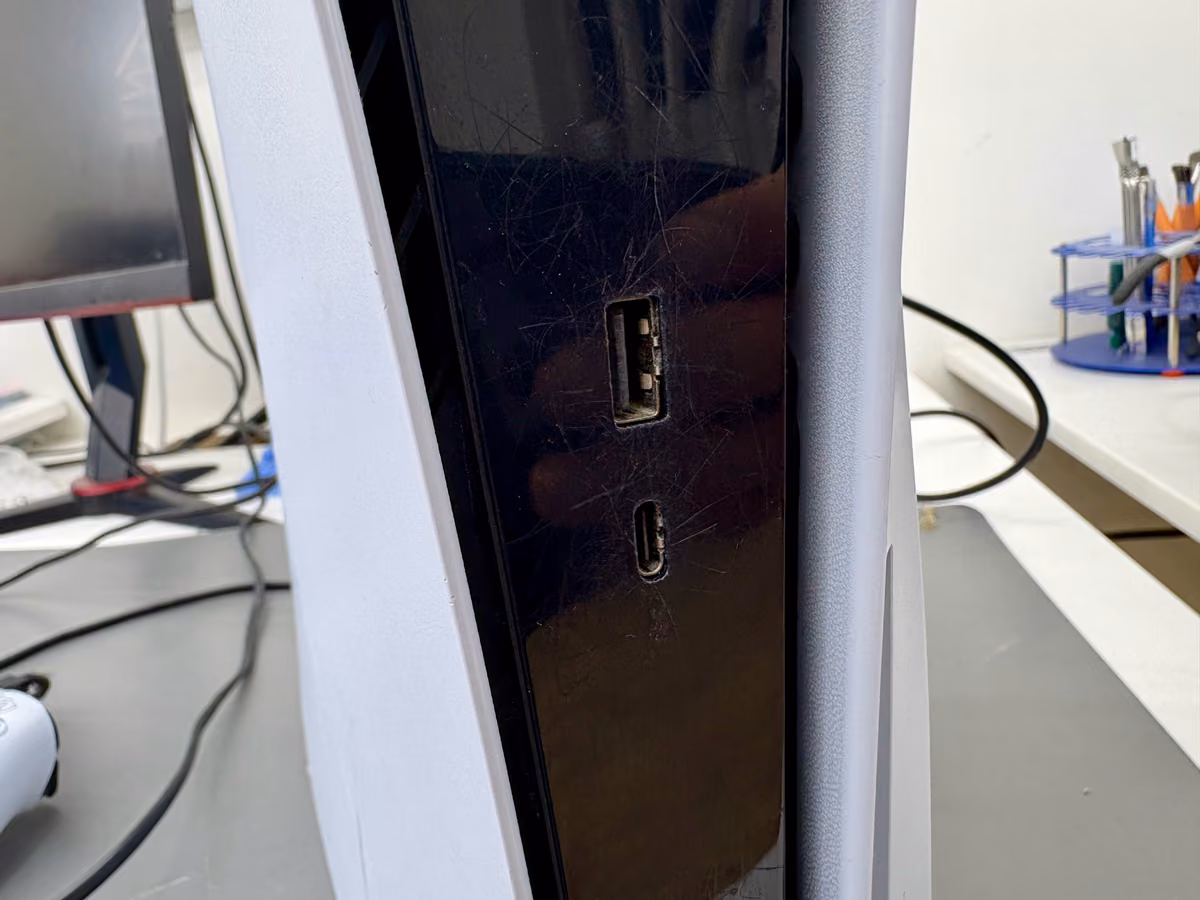Close-up van de USB-poorten aan de voorkant van een PS5 met een kabel half ingestoken