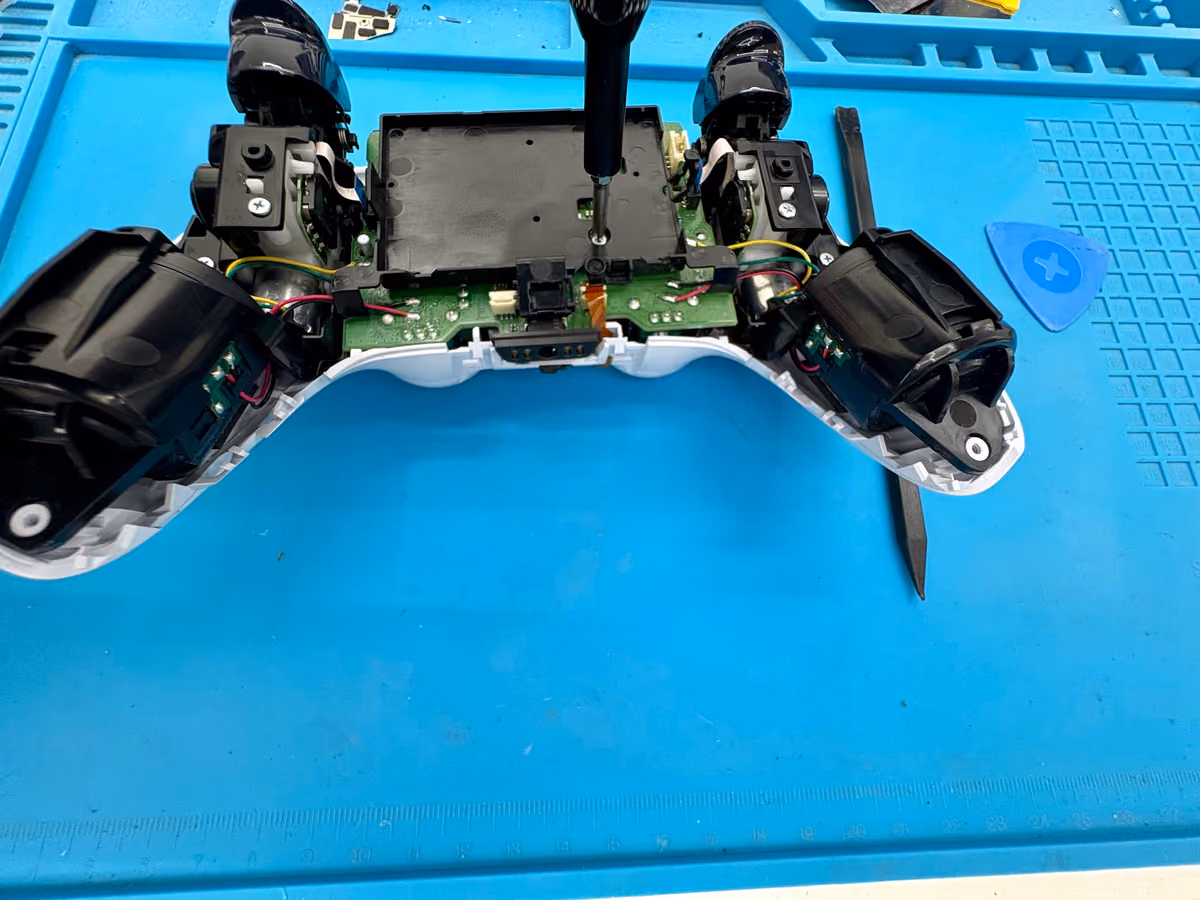 Geopende DualSense-controller op de werkbank bij FixMyTech in Rotterdam-Kralingen, klaar om de accu los te koppelen