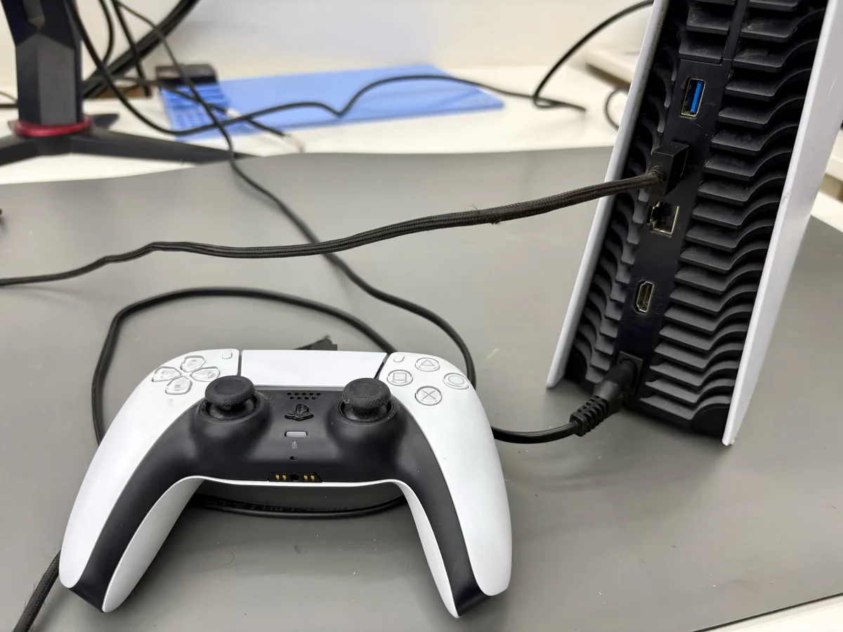 Controller die met een USB-kabel op de achterste poort van de console is aangesloten