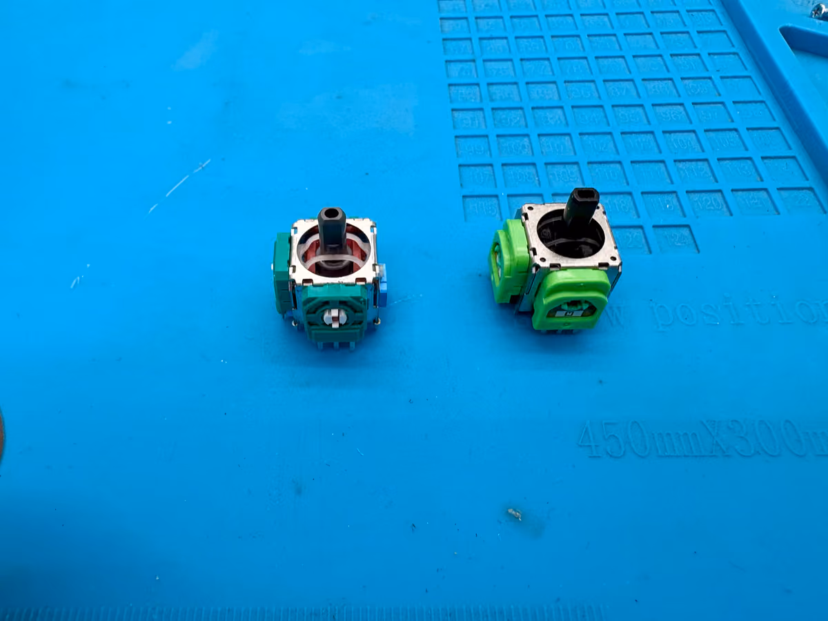 Een standaard stickmodule van een DualSense naast een magnetische TMR-module op de werkbank