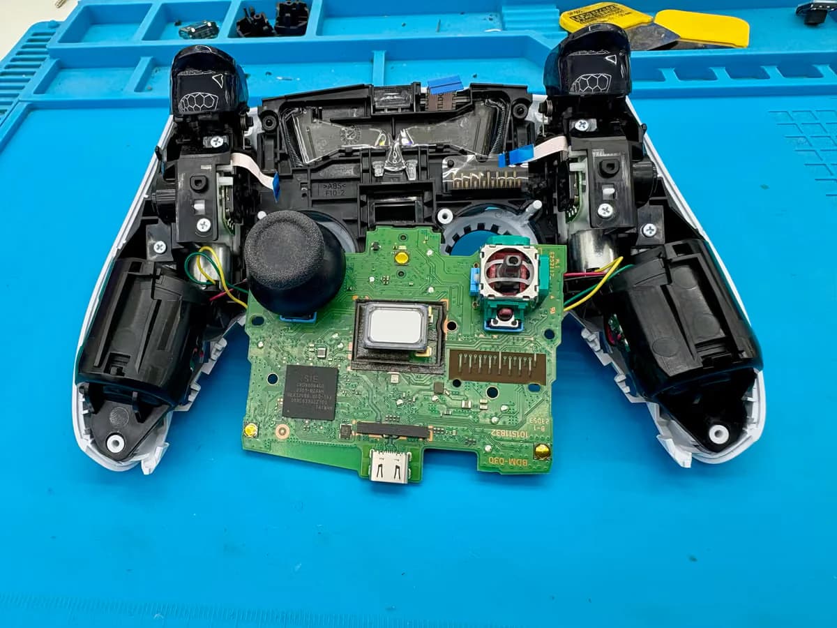 DualSense-controller geopend op de werkbank met de stickmodule zichtbaar