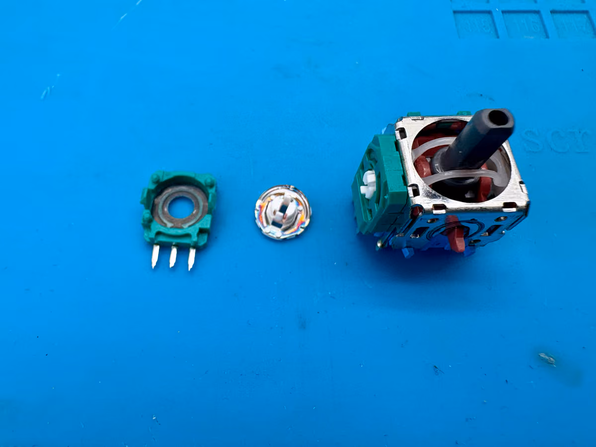 Versleten koolstofbaan in de stickmodule van een DualSense — de slijtage waar de bovenste kolom van de tabel over gaat