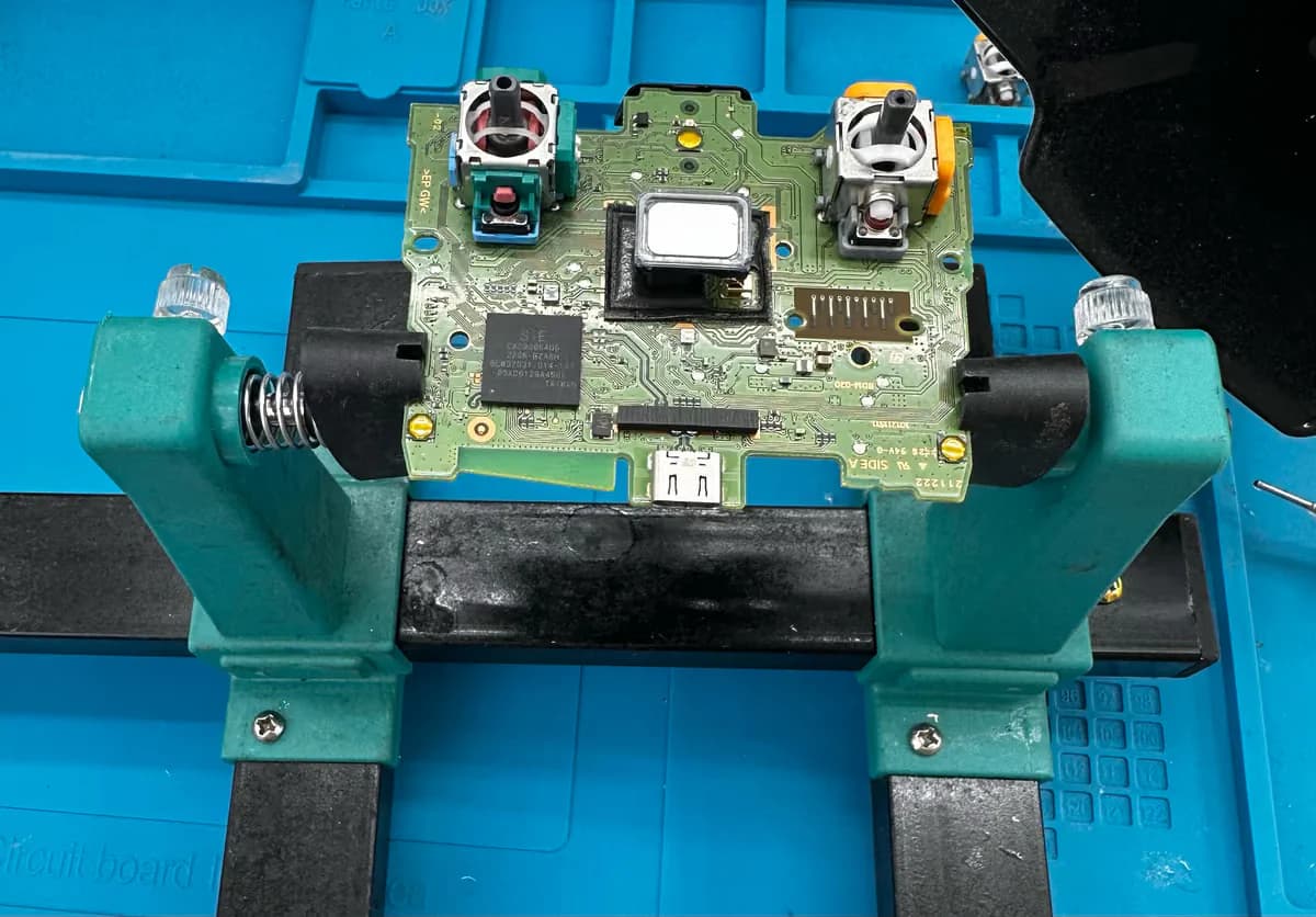De stickmodule van een DualSense wordt onder de microscoop vervangen en gesoldeerd