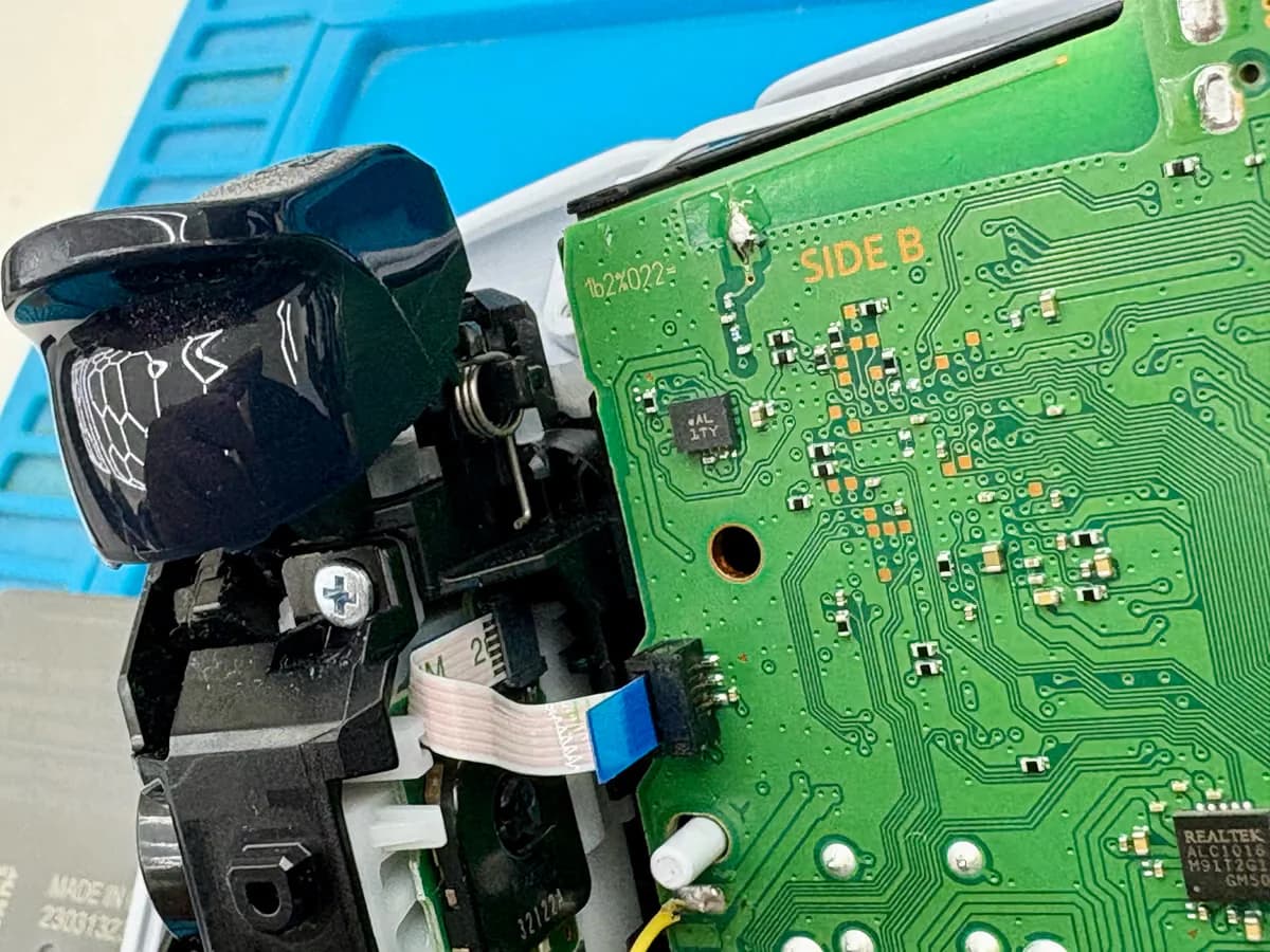 Gedemonteerde schouderknop of trigger met het veermechanisme zichtbaar