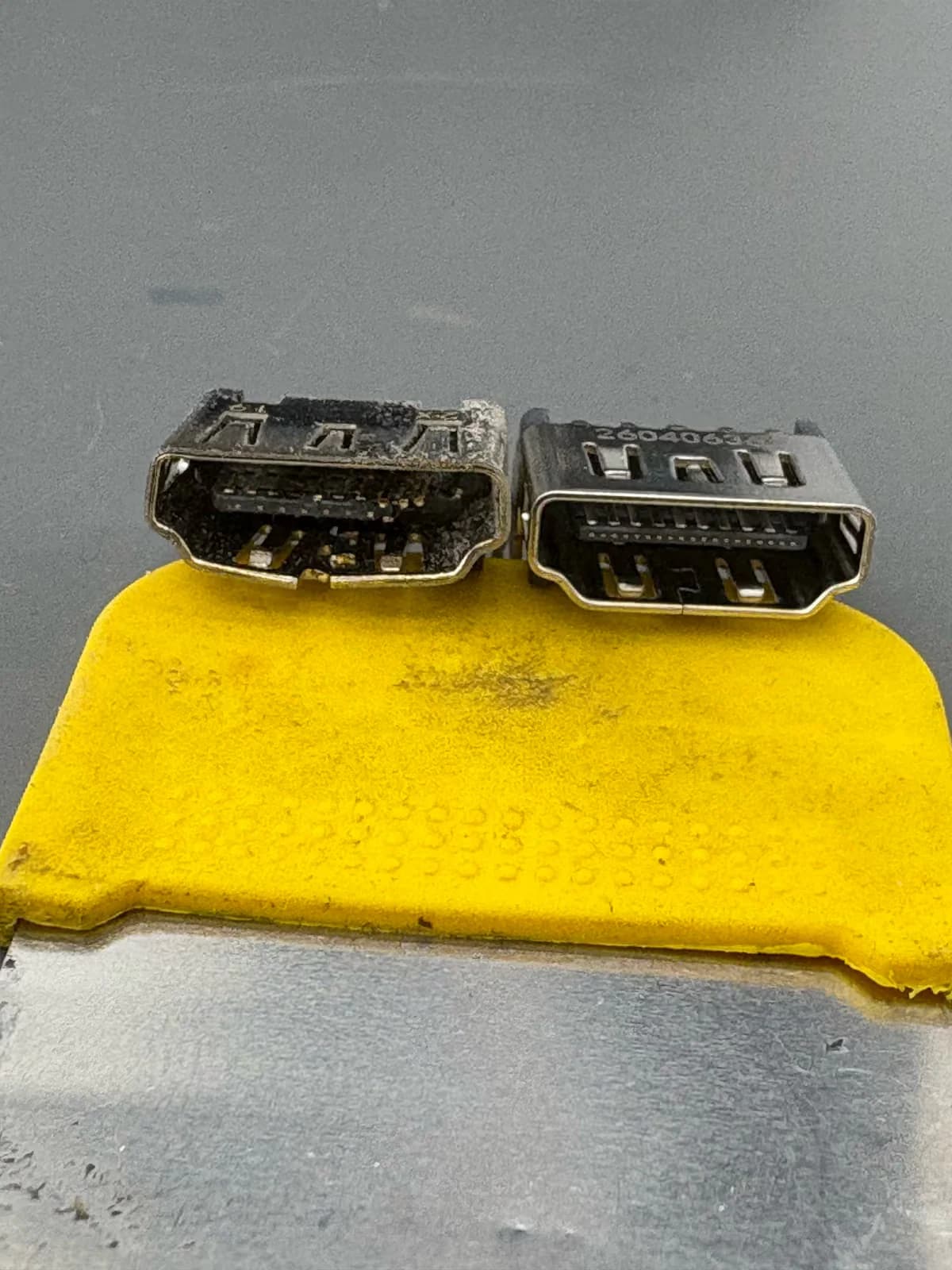 Een uitgenomen PS5 HDMI-poort naast de nieuwe poort die ervoor in de plaats komt