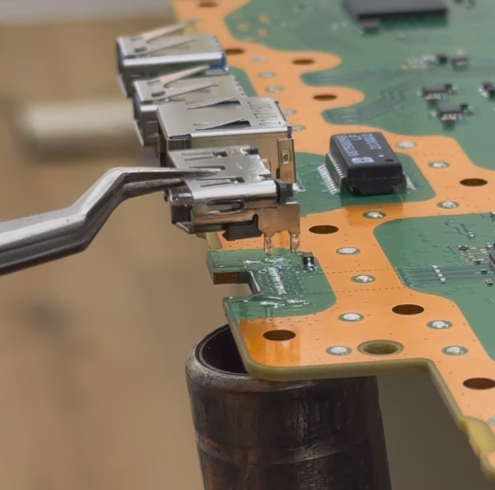 Nieuwe HDMI-poort van een PS5 wordt onder de microscoop vastgesoldeerd