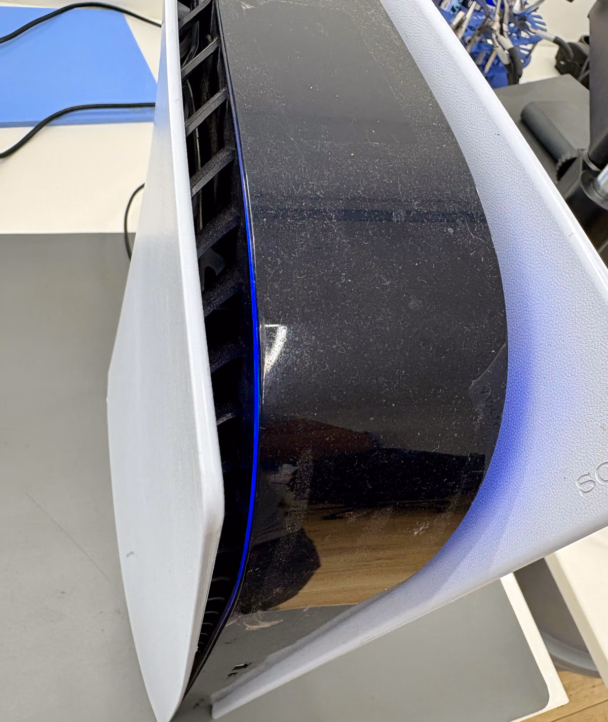 Close-up van het blauw brandende powerlampje van een PS5 vlak na het indrukken van de aan-uitknop