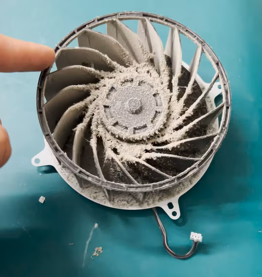 Dikke laag stof op de koelribben van een PS5, de plek waar stof kan verschroeien