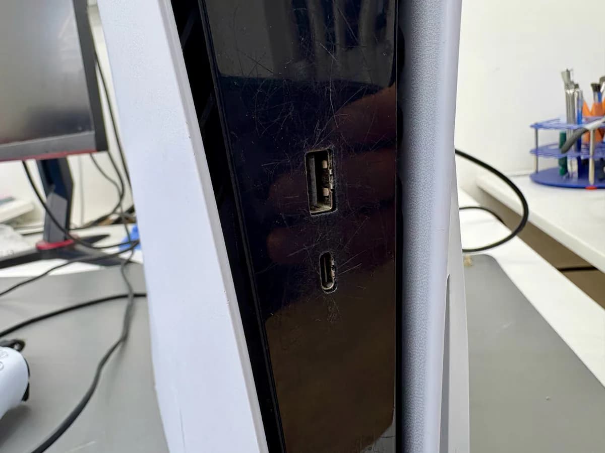Close-up van de USB-poorten aan de voorkant van een PS5 met een kabel half ingestoken