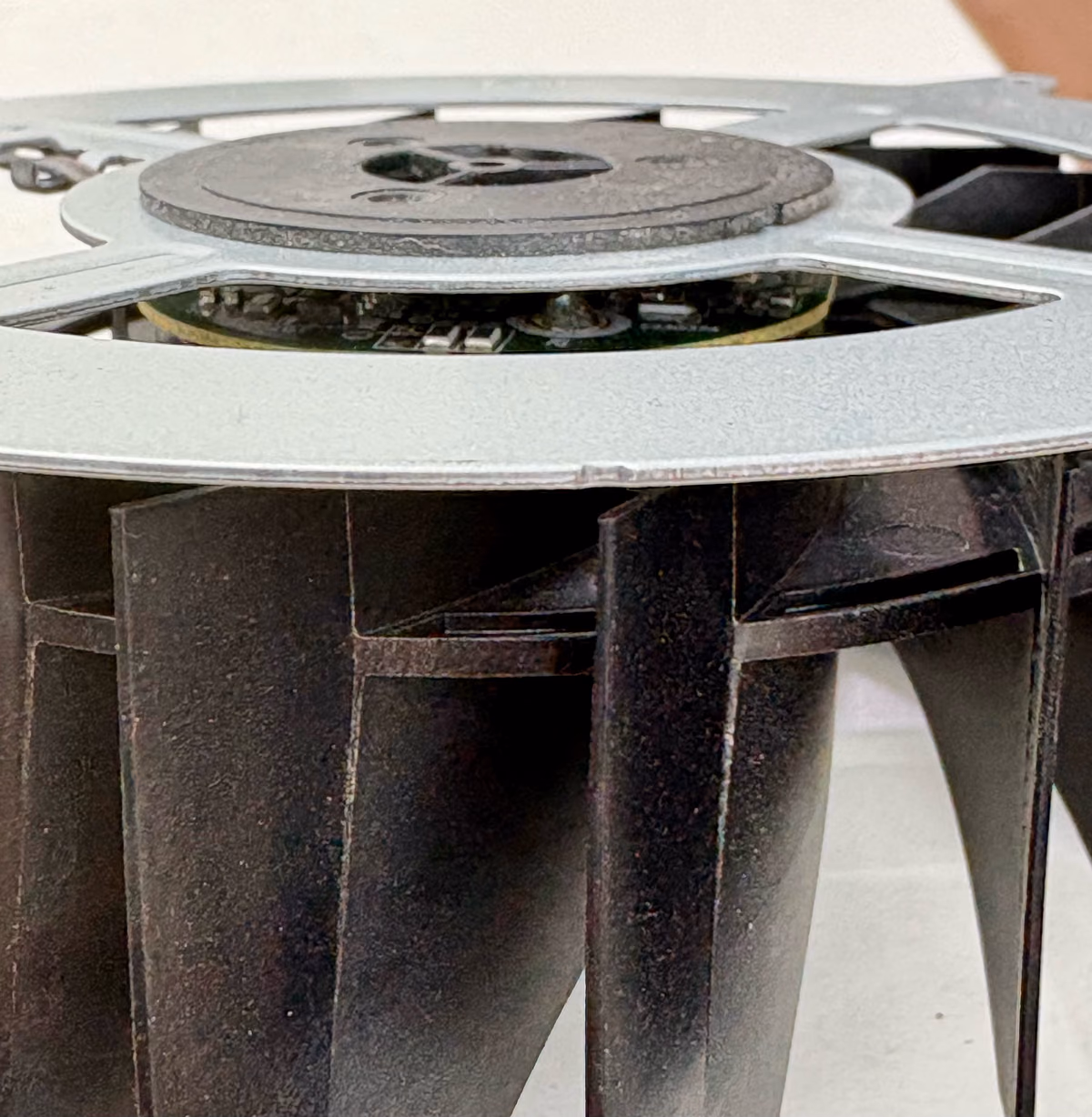 Uitgebouwde PS5-ventilator met zichtbare slijtage aan het lager in het midden